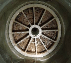 Cross-section of a fouled RO membrane element, with brown biofilm and microbial contamination visible on the feed spacers.