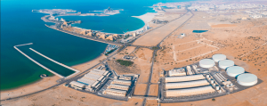 Aerial panoramic view of the Umm Al Quwain Seawater Reverse Osmosis (SWRO) Desalination Plant in the UAE, showing the extensive facility on the coastline with intake and outfall structures extending into the blue sea.